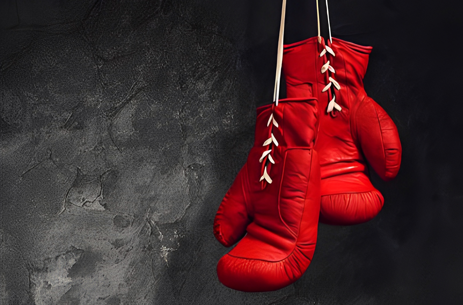 Red boxing gloves hanging on wall.
